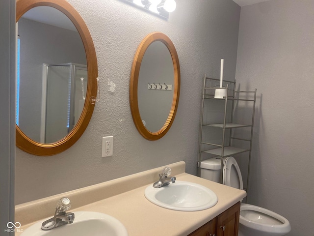 full bath with double vanity, toilet, an enclosed shower, and a sink