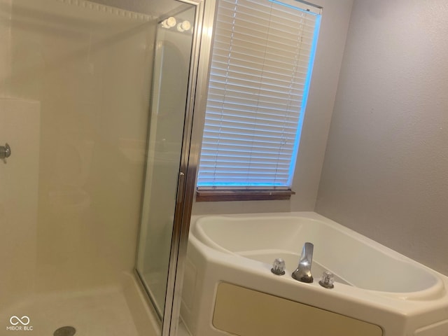 bathroom with a stall shower and a bath