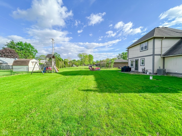 8798 Surrey Dr, Pendleton, IN 46064 - view of grassy yard with central air condition unit and a playground