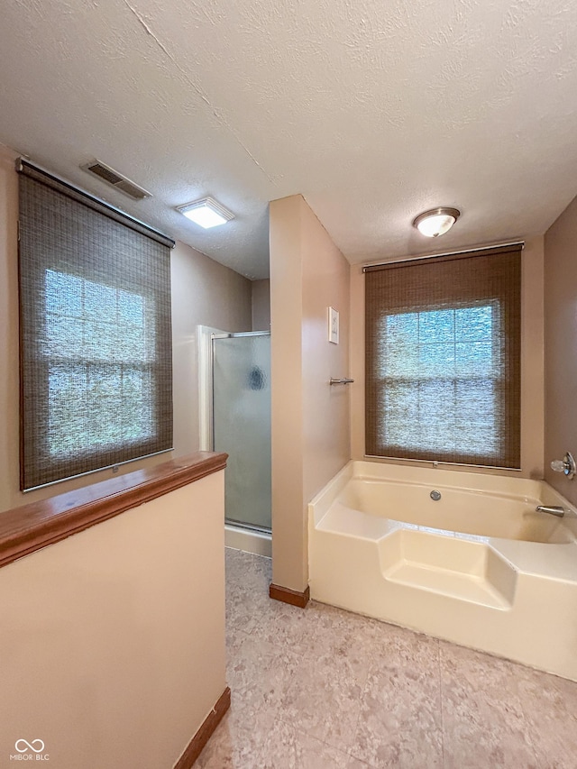 8798 Surrey Dr, Pendleton, IN 46064 - full bathroom featuring a bath, a stall shower, a textured ceiling, and baseboards