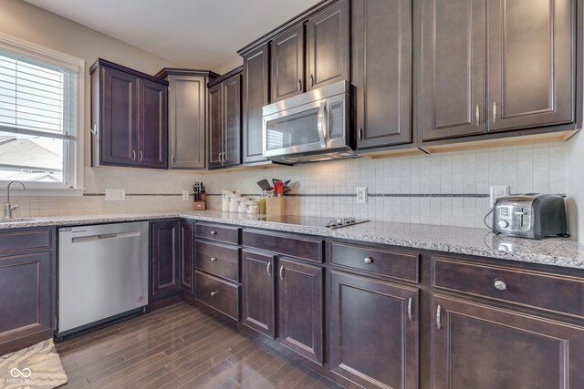 1476 Anon Ct, Greenwood, IN 46143 - kitchen with stainless steel appliances, a sink, dark wood-type flooring, tasteful backsplash, and light stone counters