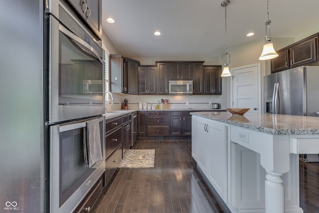 1476 Anon Ct, Greenwood, IN 46143 - kitchen featuring appliances with stainless steel finishes, dark brown cabinets, dark wood finished floors, a center island, and recessed lighting