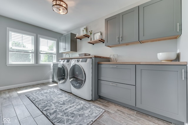 1476 Anon Ct, Greenwood, IN 46143 - laundry room with separate washer and dryer, cabinet space, baseboards, and wood finish floors