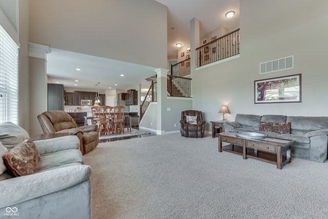 1476 Anon Ct, Greenwood, IN 46143 - living area featuring carpet floors, stairs, a high ceiling, baseboards, and recessed lighting