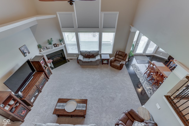 1476 Anon Ct, Greenwood, IN 46143 - living room featuring a high ceiling, a fireplace with flush hearth, a ceiling fan, and carpet