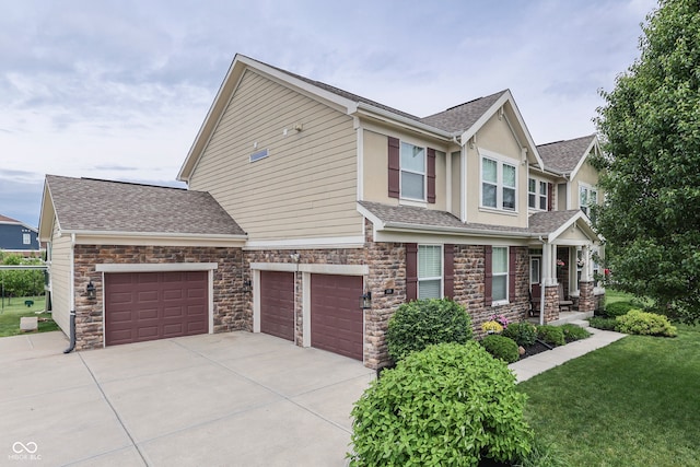 1476 Anon Ct, Greenwood, IN 46143 - view of front facade featuring concrete driveway, stucco siding, a front yard, stone siding, and a shingled roof