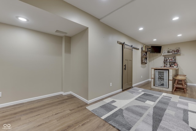 1476 Anon Ct, Greenwood, IN 46143 - basement with a barn door, a dry bar, light wood finished floors, recessed lighting, and baseboards