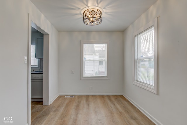 1517 Wallace Ave, Indianapolis, IN 46201 - unfurnished dining area with a chandelier, light wood-style floors, visible vents, and a healthy amount of sunlight