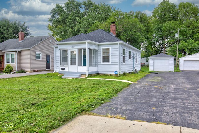 1517 Wallace Ave, Indianapolis, IN 46201 - bungalow with a chimney, an outbuilding, a garage, roof with shingles, and a front lawn