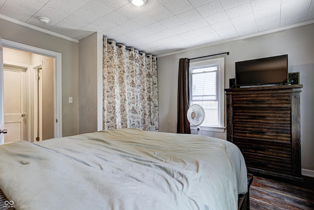 bedroom featuring crown molding and wood finished floors