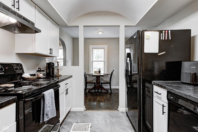 kitchen with arched walkways, black appliances, dark countertops, and under cabinet range hood