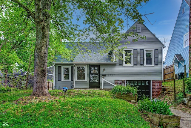 tri-level home with a front yard, an attached garage, and fence