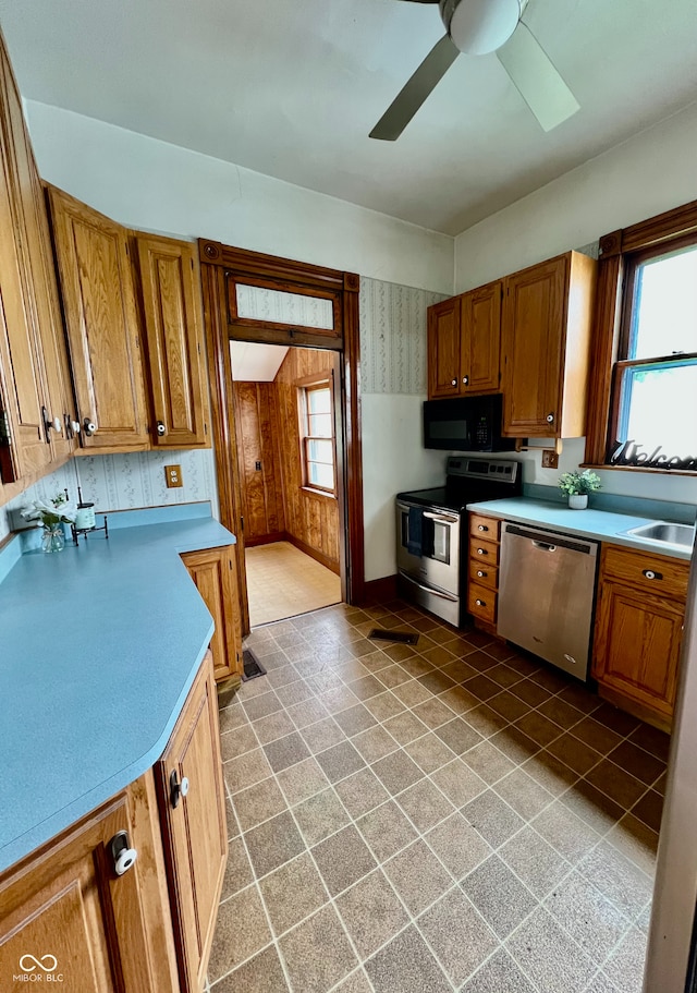 kitchen featuring ceiling fan, brown cabinetry, light countertops, and appliances with stainless steel finishes