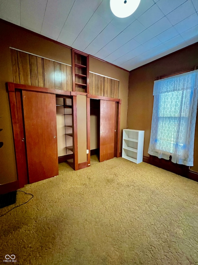 unfurnished bedroom with carpet flooring and lofted ceiling