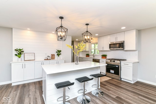 7118 Mikesell Dr, Indianapolis, IN 46260 - kitchen featuring appliances with stainless steel finishes, dark wood finished floors, baseboards, light countertops, and recessed lighting