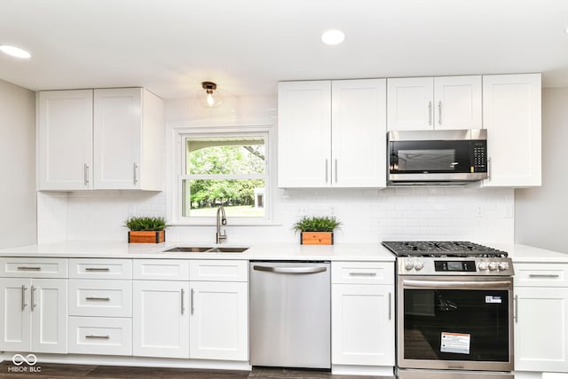 7118 Mikesell Dr, Indianapolis, IN 46260 - kitchen with stainless steel appliances, a sink, white cabinetry, light countertops, and recessed lighting