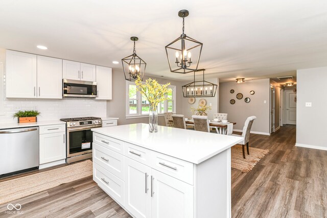 7118 Mikesell Dr, Indianapolis, IN 46260 - kitchen with stainless steel appliances, light countertops, wood finished floors, white cabinets, and recessed lighting