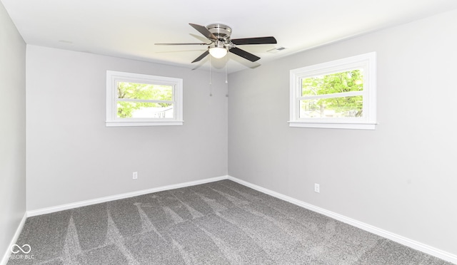 7118 Mikesell Dr, Indianapolis, IN 46260 - spare room featuring plenty of natural light, dark colored carpet, baseboards, and ceiling fan
