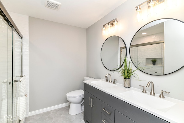 7118 Mikesell Dr, Indianapolis, IN 46260 - bathroom featuring toilet, tiled shower, double vanity, tile patterned floors, and baseboards