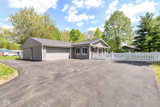 7118 Mikesell Dr, Indianapolis, IN 46260 - ranch-style home featuring fence, a garage, asphalt driveway, brick siding, and roof with shingles