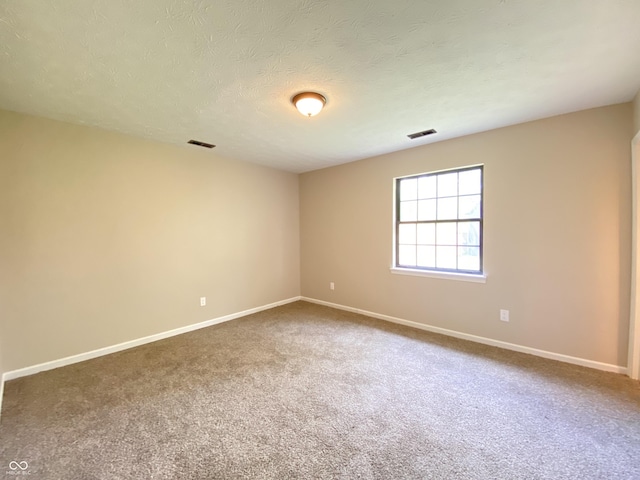 spare room featuring visible vents, baseboards, and carpet floors