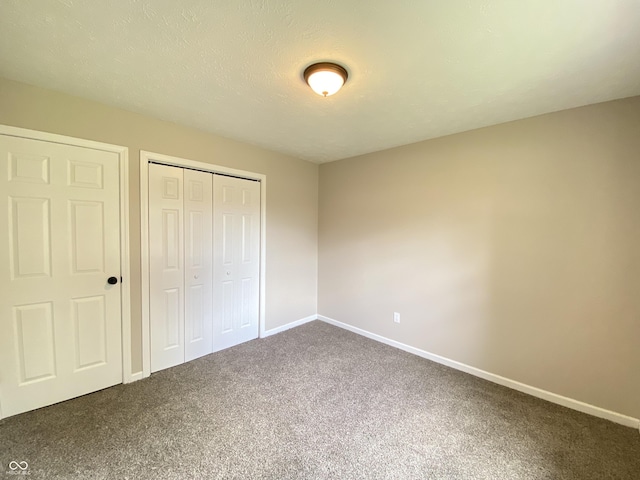 unfurnished bedroom featuring carpet, baseboards, and a closet