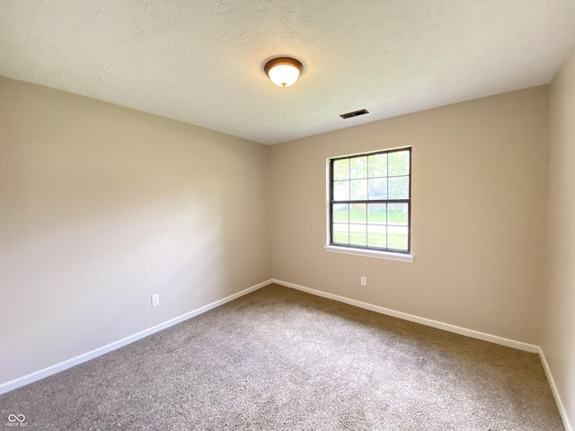 carpeted empty room featuring visible vents and baseboards