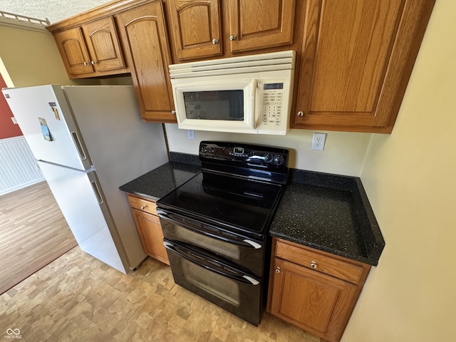 575 Mill Spgs, Coatesville, IN 46121 - kitchen featuring white appliances, brown cabinetry, and dark stone countertops