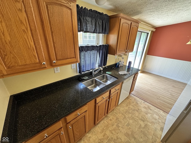 575 Mill Spgs, Coatesville, IN 46121 - kitchen featuring a sink, healthy amount of natural light, a wainscoted wall, brown cabinetry, and dishwasher