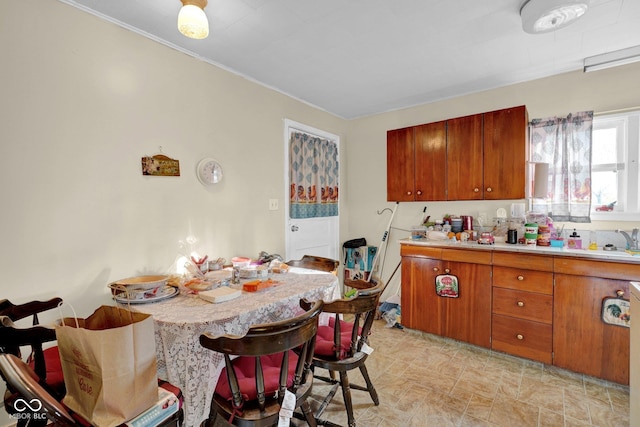 205 E Washington St, Roachdale, IN 46172 - kitchen featuring a breakfast bar, ornamental molding, brown cabinetry, and light countertops