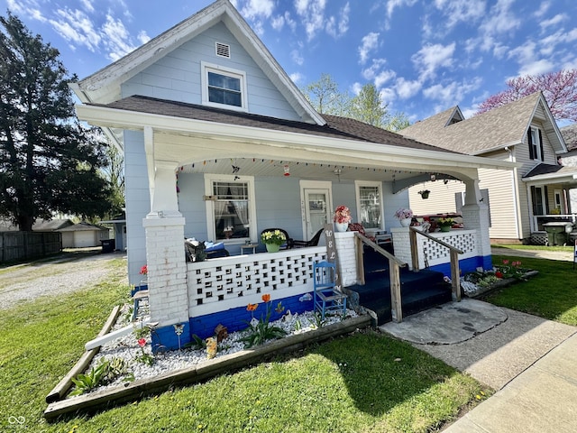 205 E Washington St, Roachdale, IN 46172 - view of front of property with a porch, roof with shingles, and a front lawn