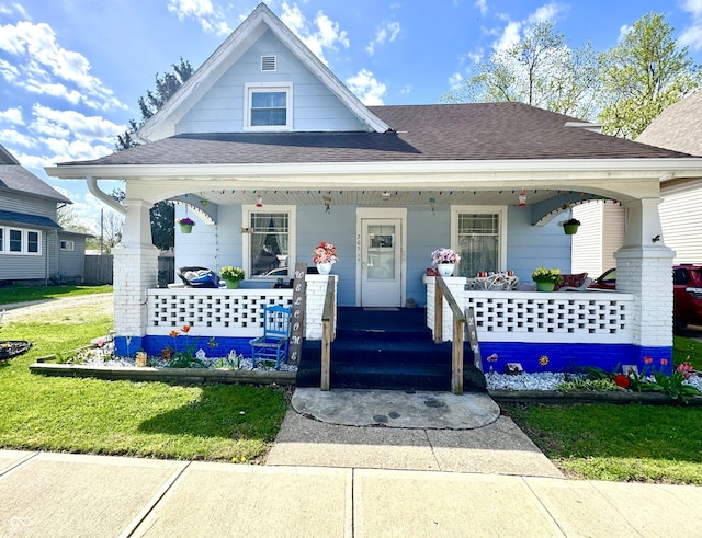 205 E Washington St, Roachdale, IN 46172 - bungalow-style house with a porch, roof with shingles, and a front lawn