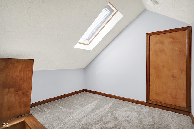 11471 Clarkston Rd, Zionsville, IN 46077 - additional living space with a skylight, vaulted ceiling, carpet flooring, baseboards, and a textured ceiling