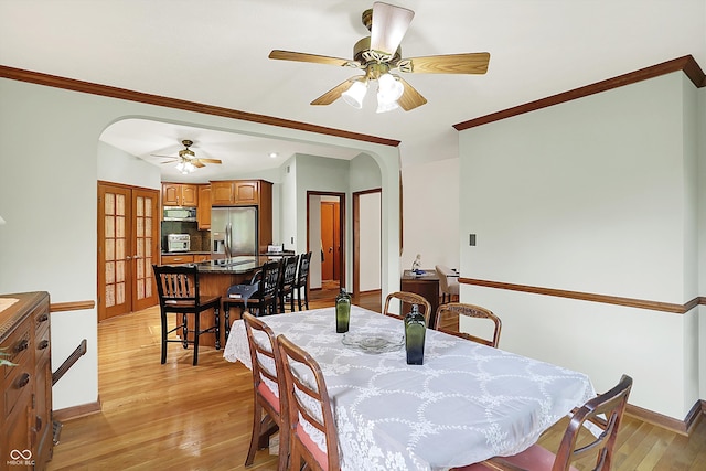 11471 Clarkston Rd, Zionsville, IN 46077 - dining area with arched walkways, crown molding, ceiling fan, light wood-type flooring, and baseboards