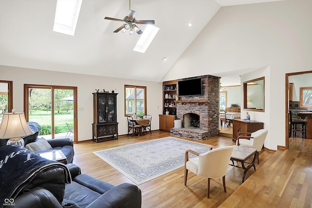 11471 Clarkston Rd, Zionsville, IN 46077 - living area with a skylight, high vaulted ceiling, a fireplace, light wood-style flooring, and a ceiling fan