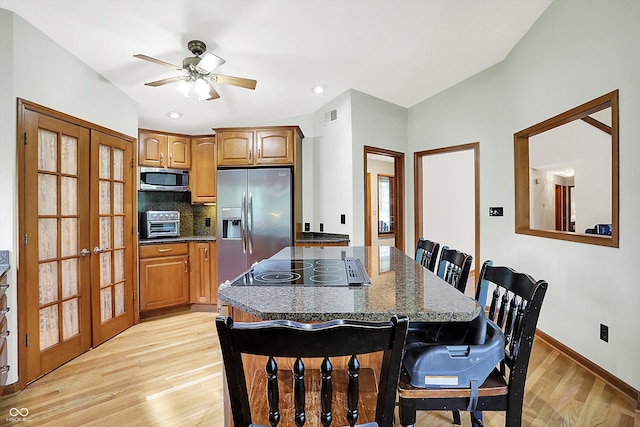 11471 Clarkston Rd, Zionsville, IN 46077 - kitchen with stainless steel appliances, french doors, light wood-style floors, a kitchen breakfast bar, and decorative backsplash