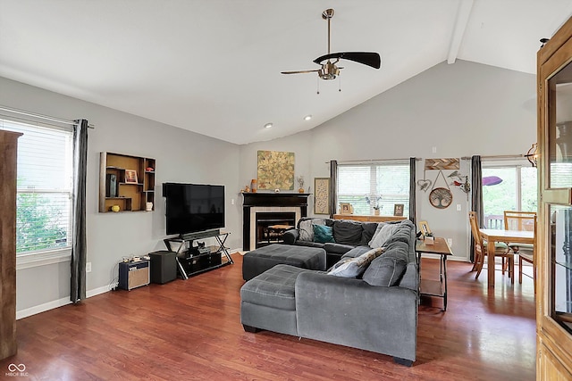 living room with ceiling fan, healthy amount of natural light, beam ceiling, wood finished floors, and high vaulted ceiling