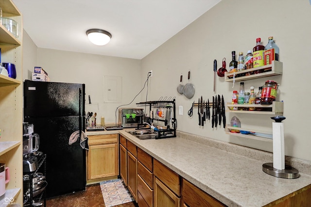 kitchen with freestanding refrigerator, open shelves, light countertops, a sink, and brown cabinetry
