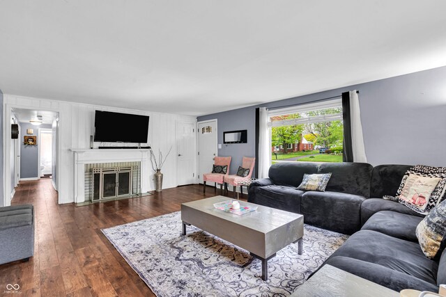 living room with wood-type flooring and a brick fireplace