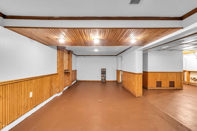 finished basement featuring wood walls, a wainscoted wall, and baseboards