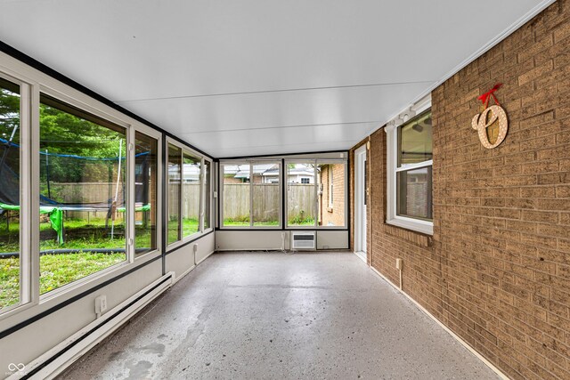 unfurnished sunroom with a baseboard heating unit and a wall unit AC