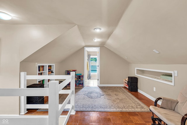 bonus room with built in features, vaulted ceiling, baseboards, and wood finished floors