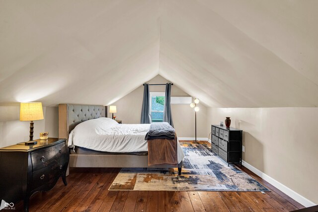 bedroom with hardwood / wood-style flooring, lofted ceiling, and baseboards