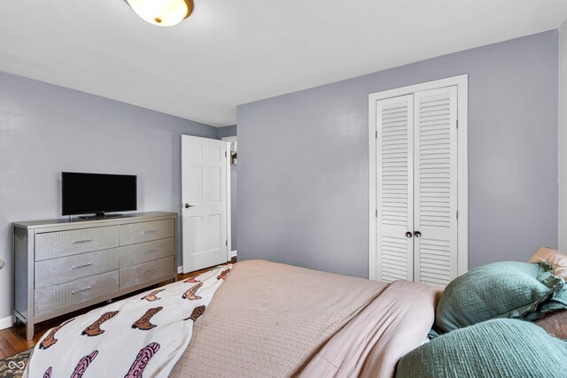 bedroom featuring a closet, wood finished floors, and baseboards