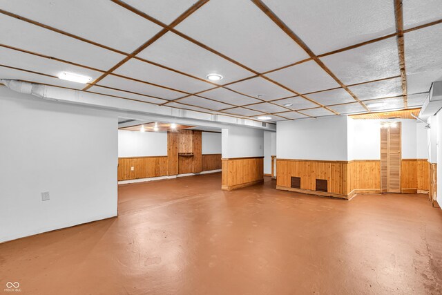 finished below grade area with wooden walls and a wainscoted wall
