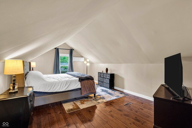 bedroom with hardwood / wood-style flooring, lofted ceiling, and baseboards