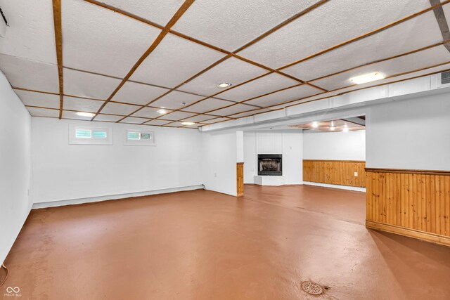 below grade area featuring a fireplace, wooden walls, wainscoting, and recessed lighting
