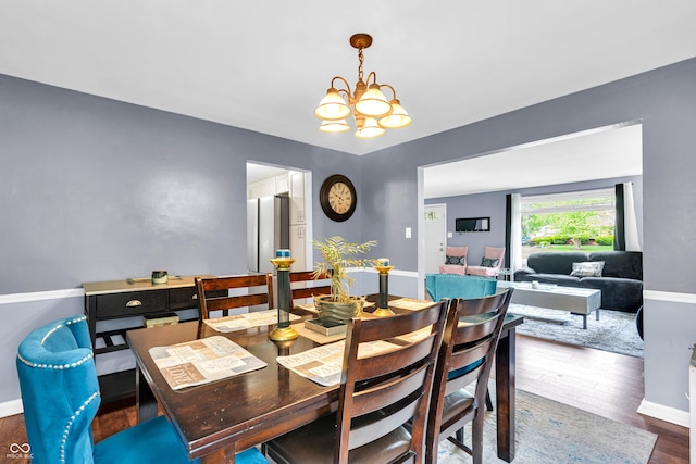 dining room with a chandelier, baseboards, and wood finished floors