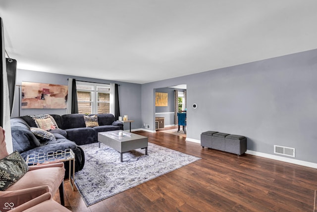 living area with healthy amount of natural light, wood finished floors, and baseboards