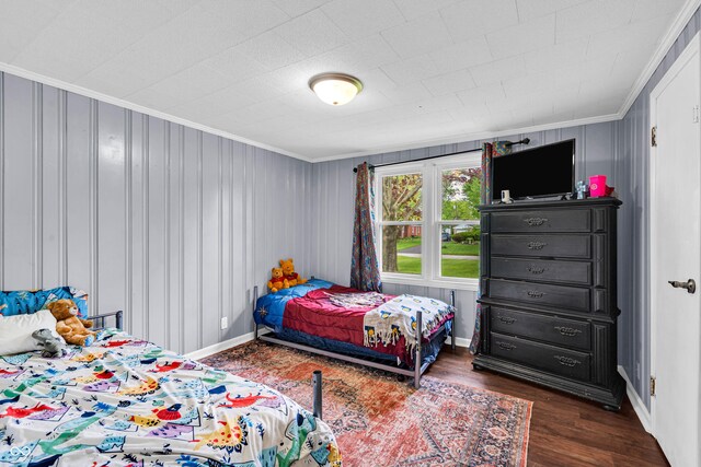 bedroom featuring ornamental molding and wood finished floors